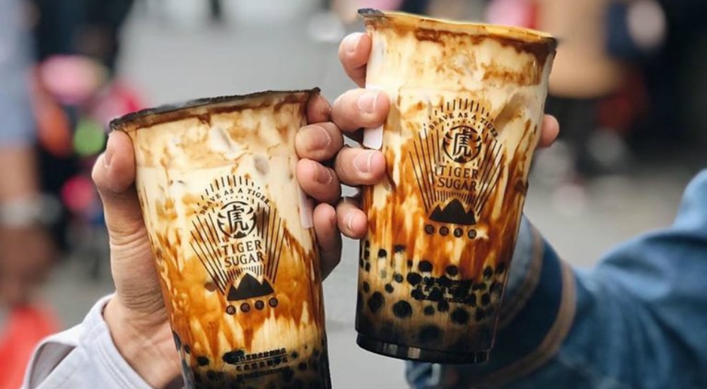two cups of brown sugar boba tea with swirling brown colors.