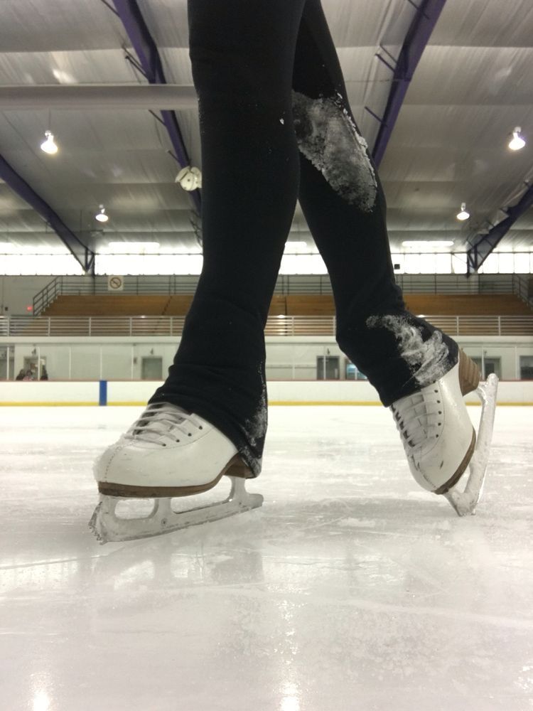 white ice skating boots on an ice skating rink.