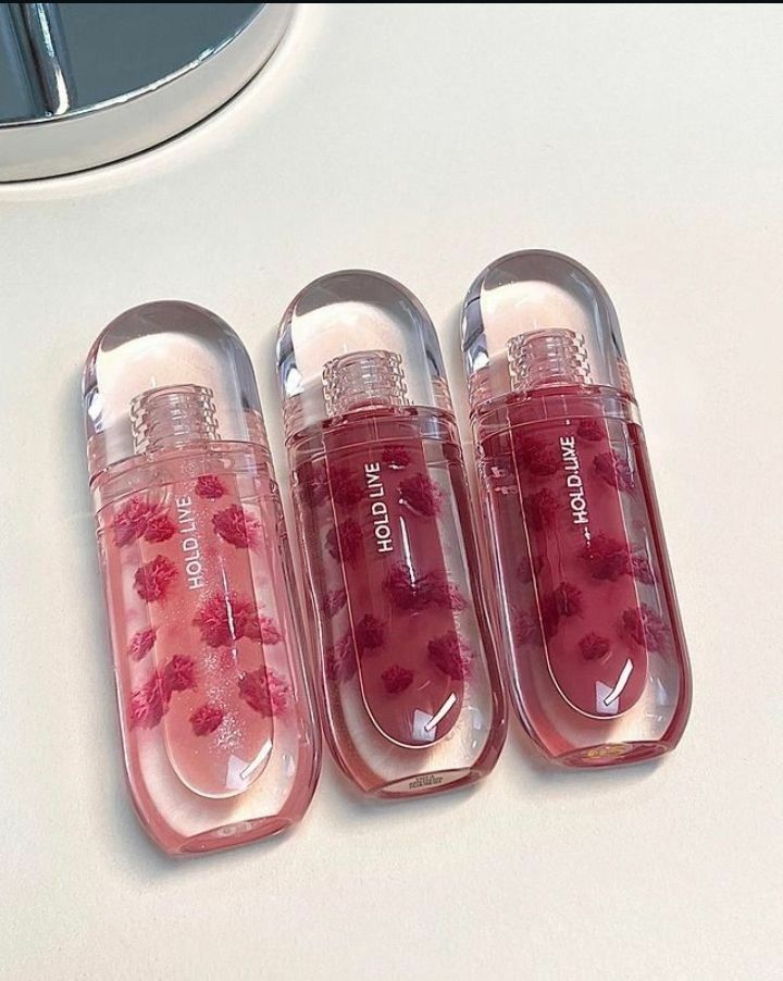 three cute rosy shades of lip gloss in little pink containers.